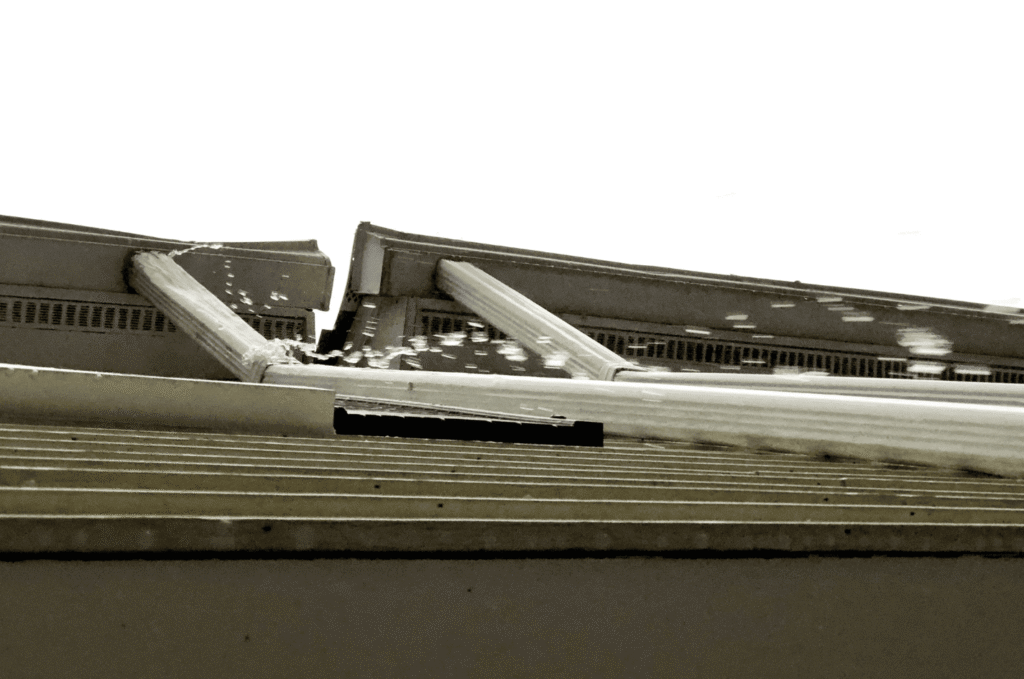 Water overflowing from a gutter near the fascia board, showing a common cause of fascia board water damage and rot on a home