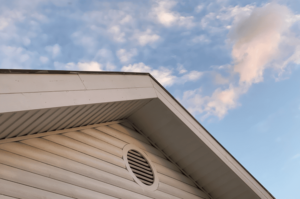 House eaves with a visible soffit area and gable vent, showing how attic ventilation supports airflow beneath the roofline.