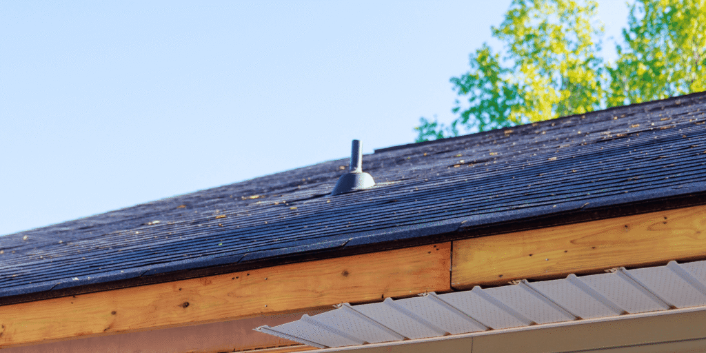 Damaged flat roof membrane near rooftop equipment showing surface wear, cracks, and hidden leak risk on a commercial roof