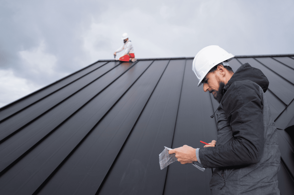 Roofing professional taking notes during an inspection, part of a proactive commercial roof maintenance plan for summer

