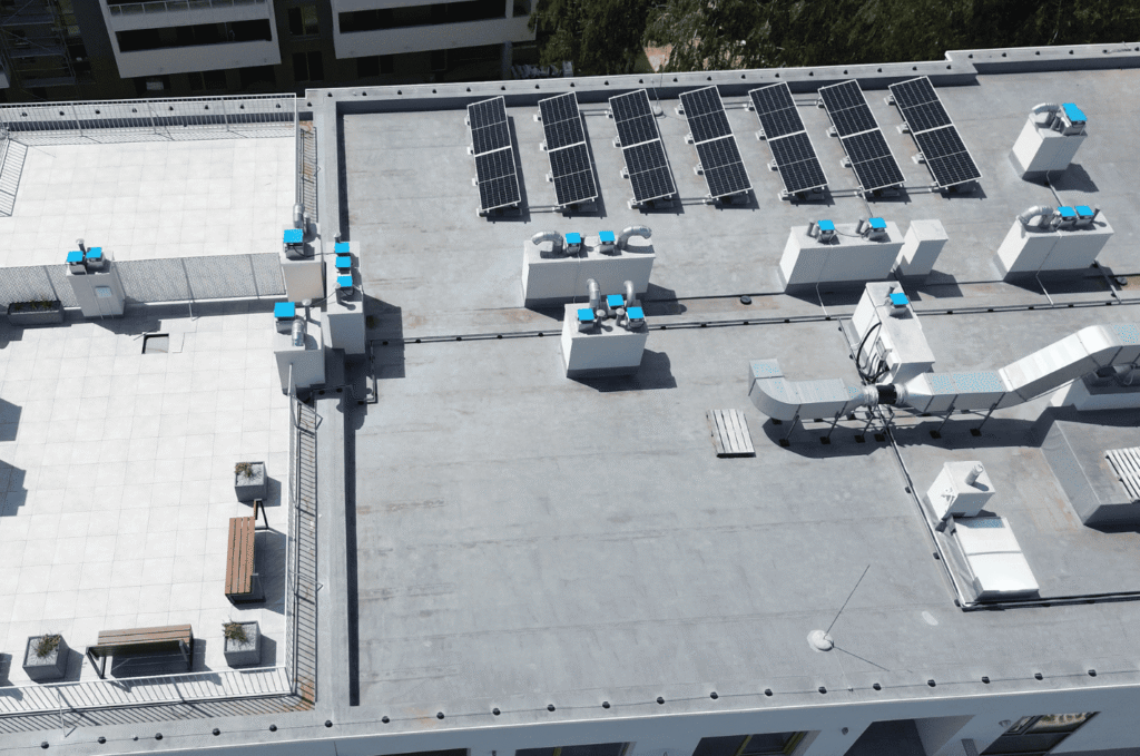 Aerial view of rooftop HVAC units and vents on a flat commercial roof, key penetration points in commercial roof maintenance