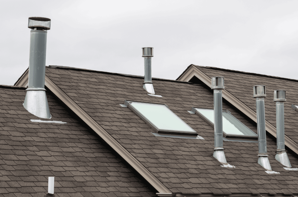 Several roof vents and pipe boots on an asphalt shingle roof, the penetration points behind most roof vent leak causes