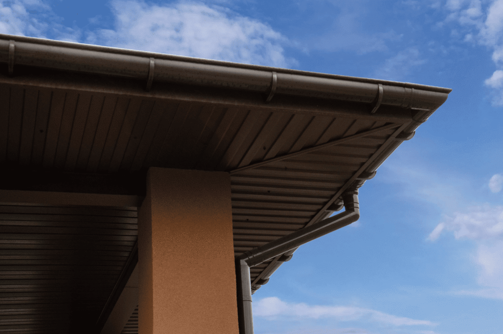 Roof overhang showing the soffit panel, fascia board, and gutter, the parts most affected by soffit and fascia damage