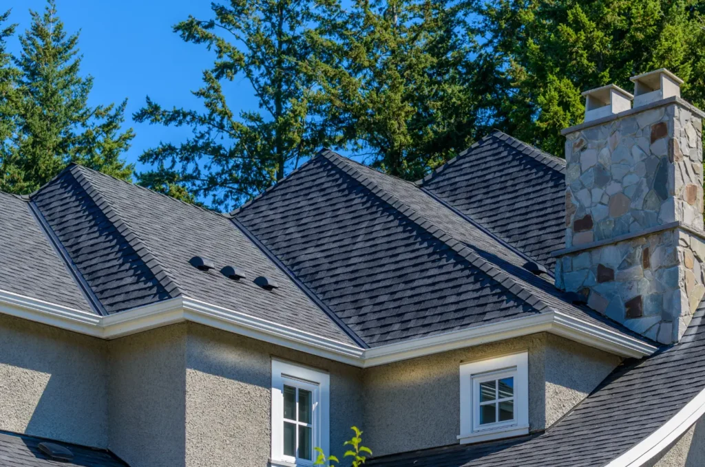 Roof repair work on an asphalt shingle roof with worn areas being fixed
