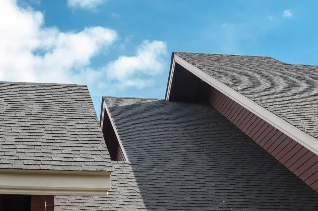 Asphalt roofing materials installed in neat rows across a sloped home roof.