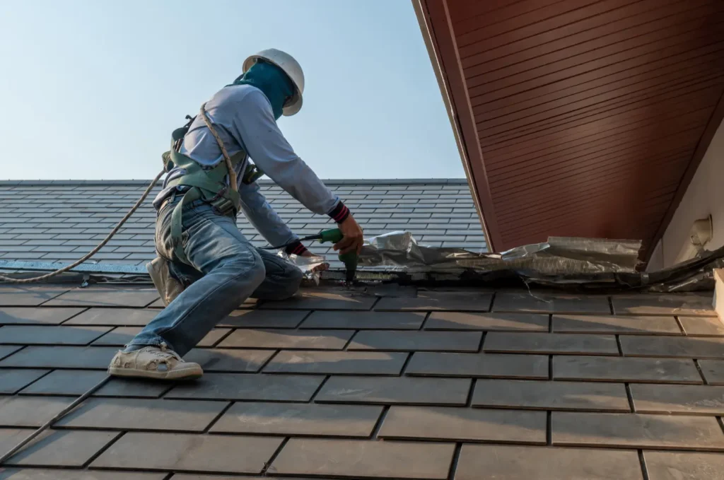 Workers completing a roof replacement on a home with fresh asphalt shingles