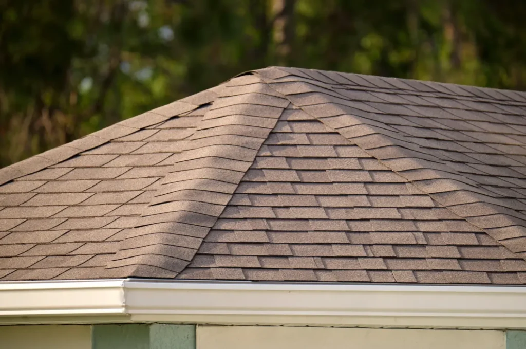 Older home with a weathered asphalt shingle roof showing visible wear after years of exposure