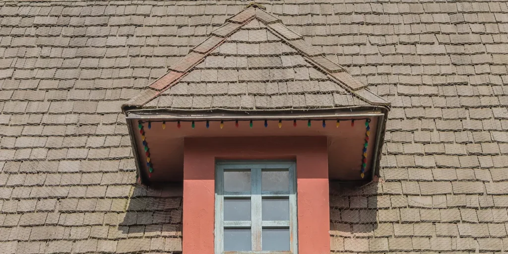 Old asphalt shingle roof showing signs of aging, weather damage, and worn shingles