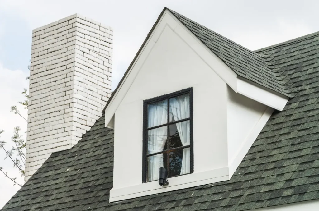 Residential roof with old asphalt shingles showing discoloration and surface deterioration