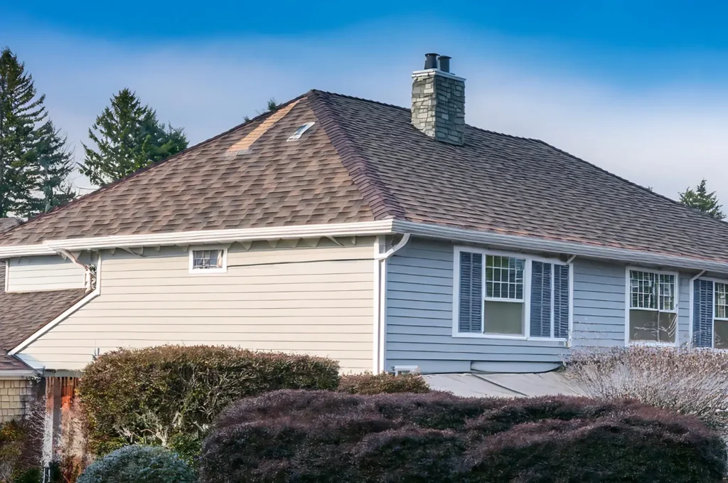 Residential asphalt roof with intact shingles following localized roof patching work